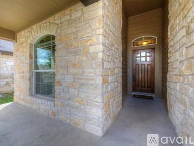 A stone house with a brown door and window.