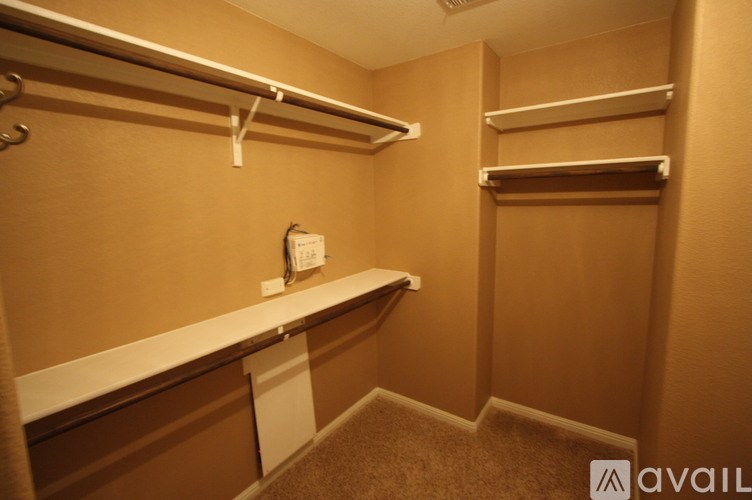 A small, empty room with a white shelf and a white door.