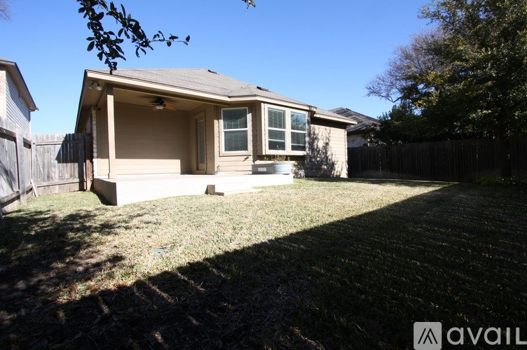 A house with a fence and a tree in the front yard.