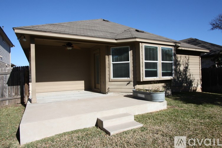 A house with a grey roof and a white door is for sale.
