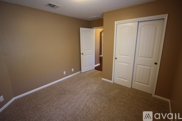 A room with two doors and a carpeted floor.