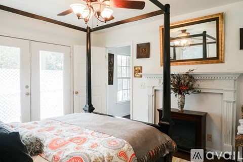 A bedroom with a four poster bed and a fireplace.