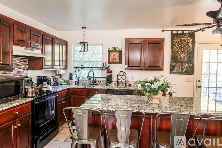 A kitchen with dark wood cabinets and a granite countertop.
