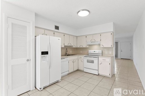 A kitchen with white appliances and cabinets.