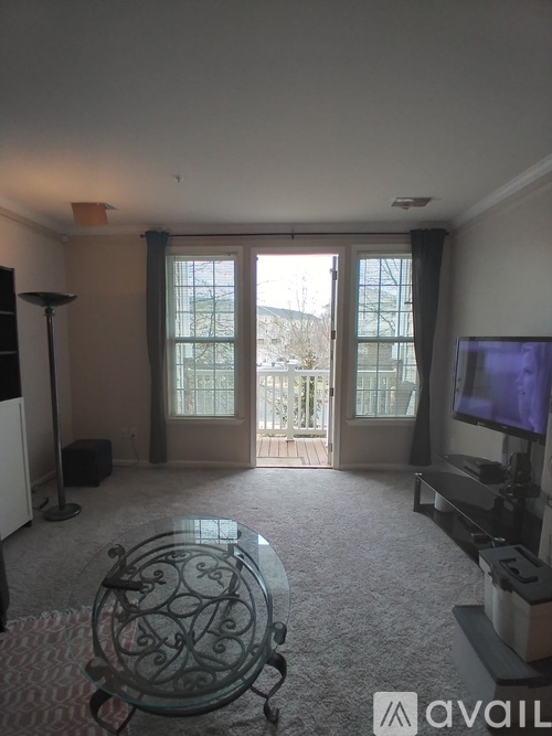 A living room with a glass table and a television.