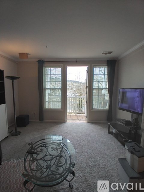 A living room with a glass table and a television.