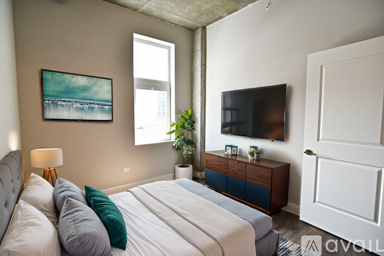 A bedroom with a large bed and a painting on the wall.