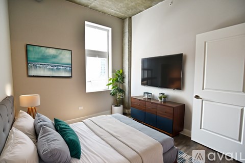 A bedroom with a large bed and a painting on the wall.