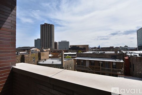 A view from a balcony overlooking a cityscape with buildings of various heights.