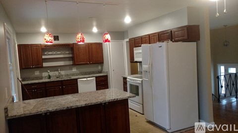 A kitchen with granite countertops and white appliances.