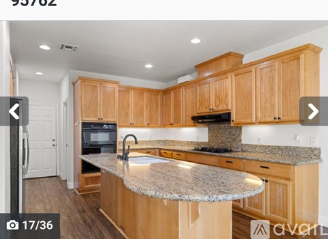 A kitchen with wooden cabinets and granite countertops.