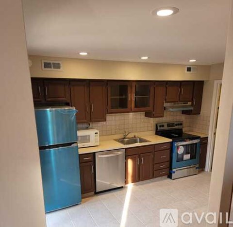 A kitchen with a blue refrigerator and brown cabinets.