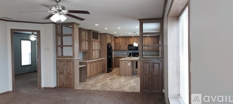 A kitchen with wooden cabinets and a ceiling fan.