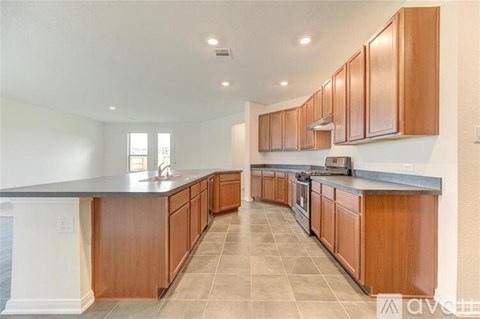 A kitchen with wooden cabinets and a black countertop.