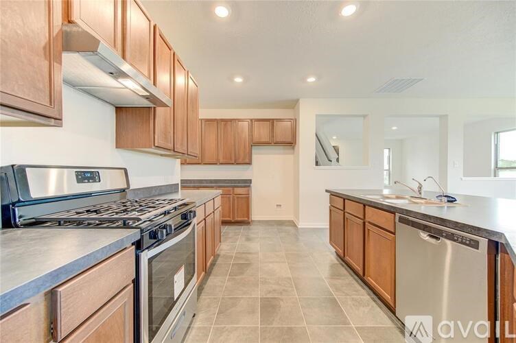 A kitchen with wooden cabinets and a stainless steel dishwasher.