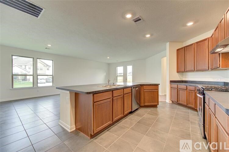 A kitchen with wooden cabinets and a large island.