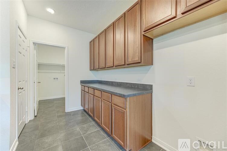 A kitchen with wooden cabinets and a marble countertop.