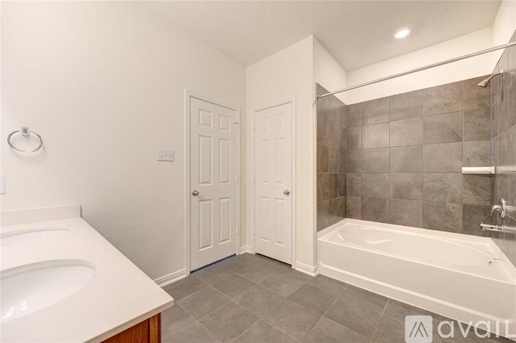 A bathroom with a white tub and sink.