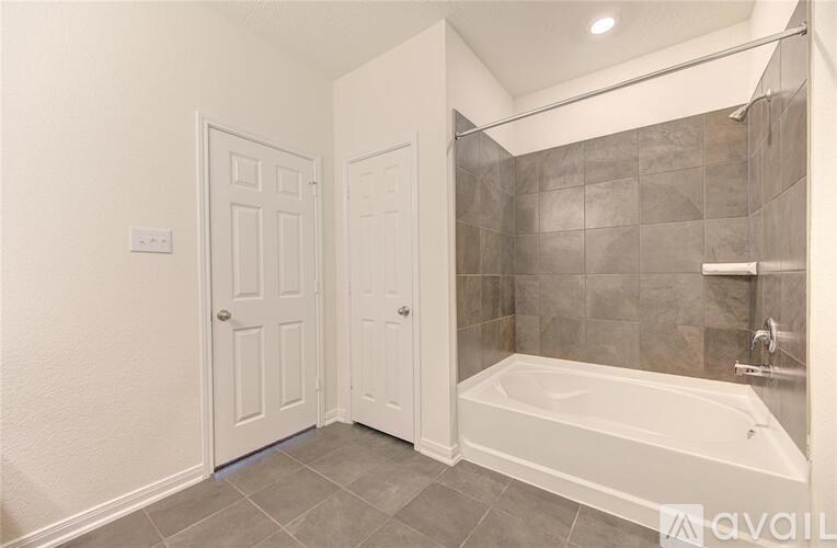 A bathroom with a tub and two doors.