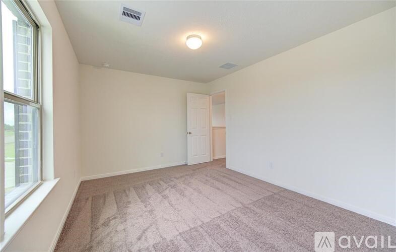 A room with a carpeted floor and a window on the left side.