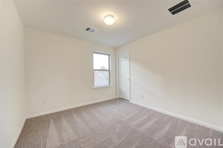 A room with a carpeted floor and a window.