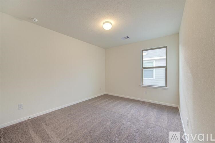 A room with a window and carpeted floor.