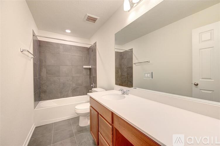 A bathroom with a white counter top and a white toilet.