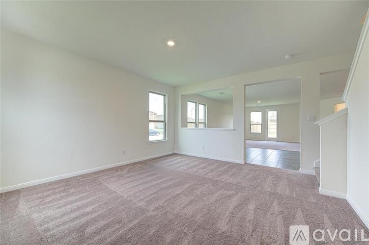 A large empty room with carpeted floor and a mirror on the wall.