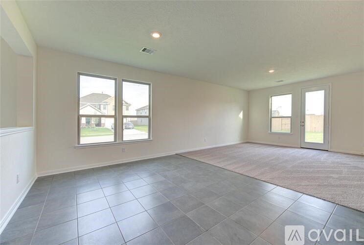A spacious room with tile flooring and large windows.