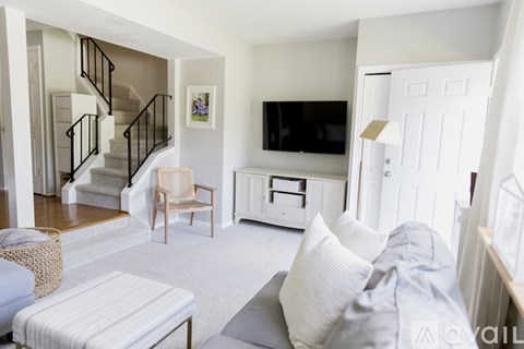 A living room with a grey couch and a wooden chair.