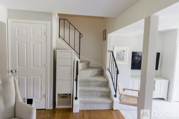 A white chair is in front of a white door.