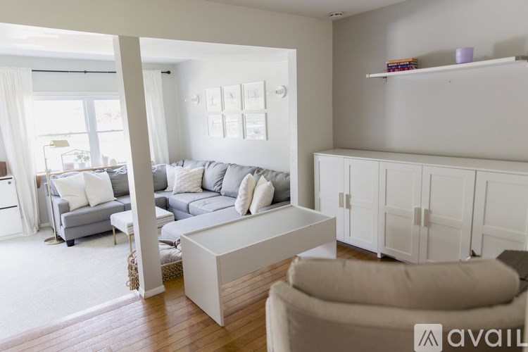 A living room with a grey couch and a white coffee table.