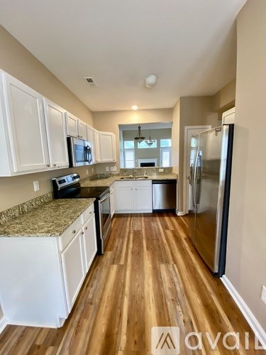 A kitchen with white cabinets and a granite countertop.