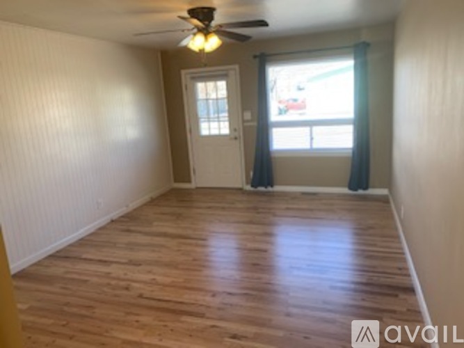 A room with wooden flooring and a ceiling fan.