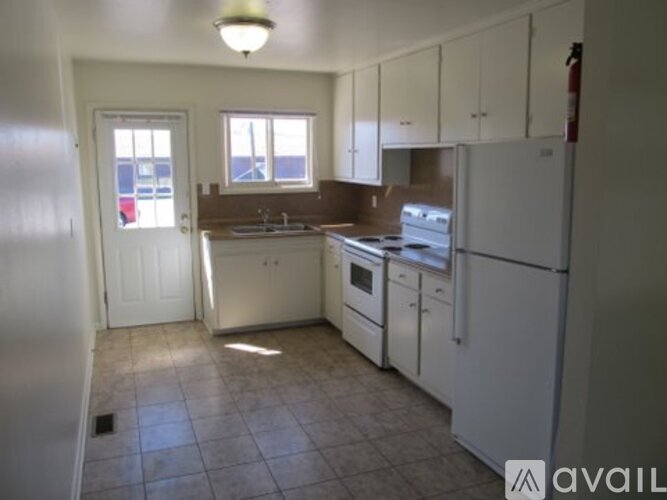 A kitchen with white appliances and cabinets.