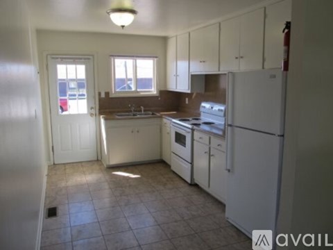 A kitchen with white appliances and cabinets.