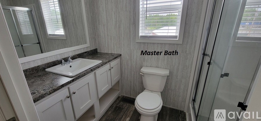 A bathroom with a sink, toilet and a window.