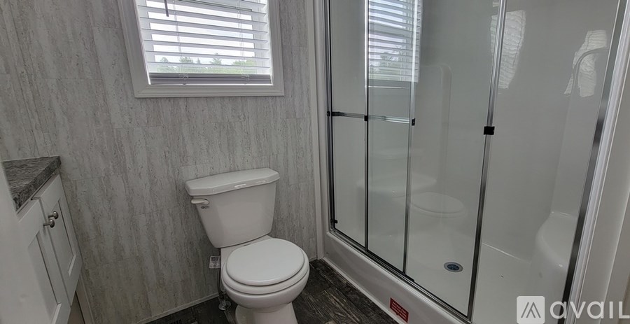 A white toilet in a bathroom with a glass shower door.
