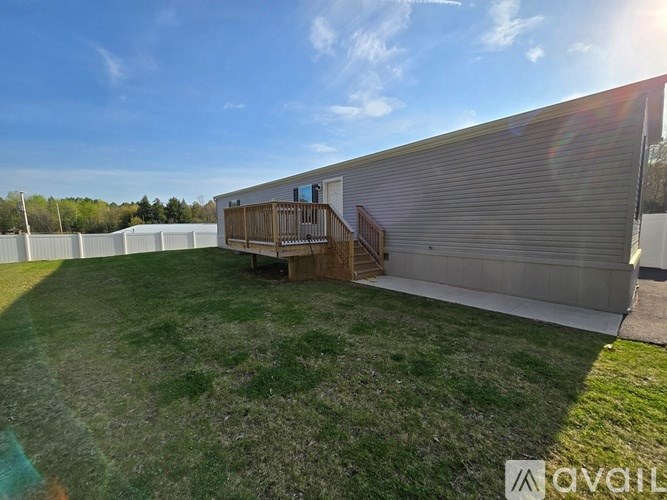A backyard with a deck and a fence.