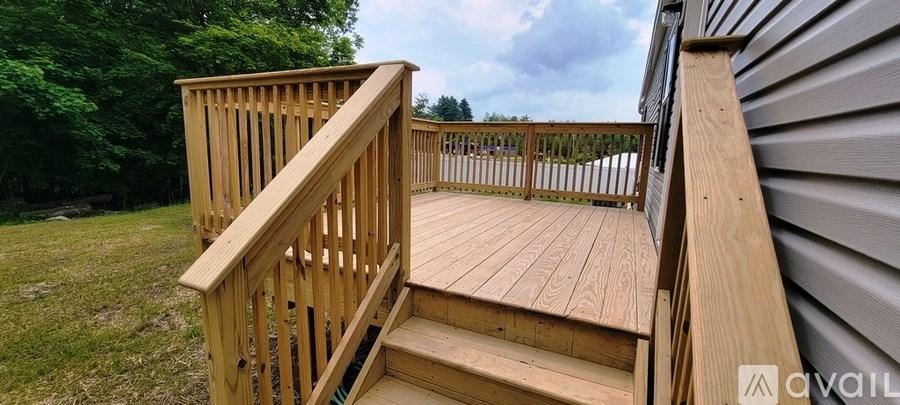 A wooden deck with a staircase leading to a house.