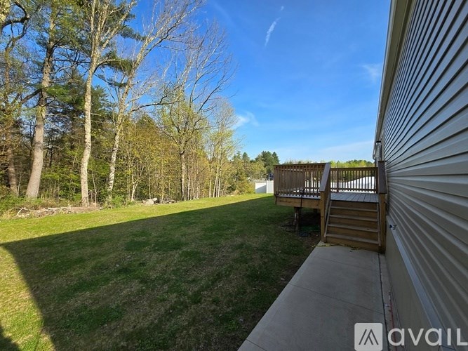 A backyard with a deck and trees.
