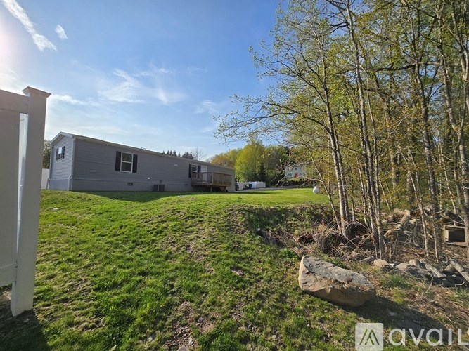 A house with a yard and trees in the background.