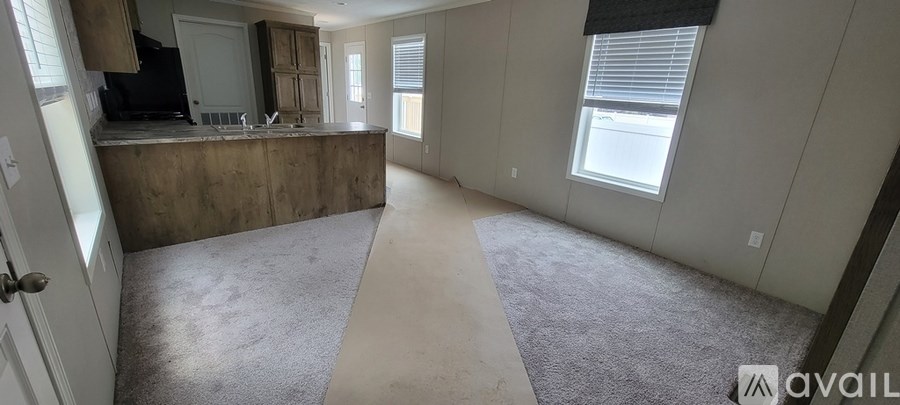 A large open room with a bar and a window.