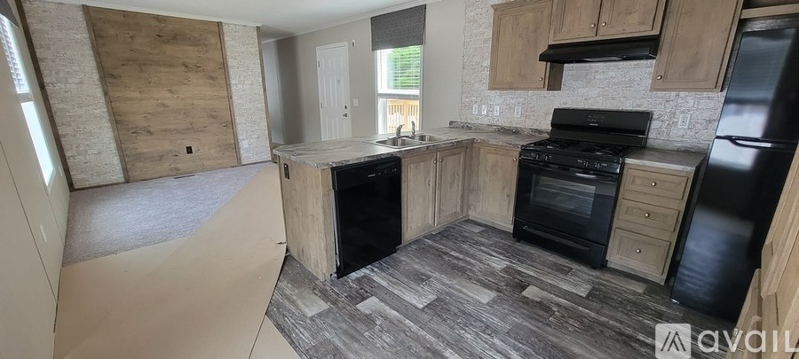 A kitchen with black appliances and wooden cabinets.