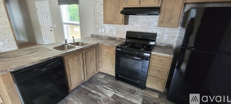 A kitchen with black appliances and wooden cabinets.