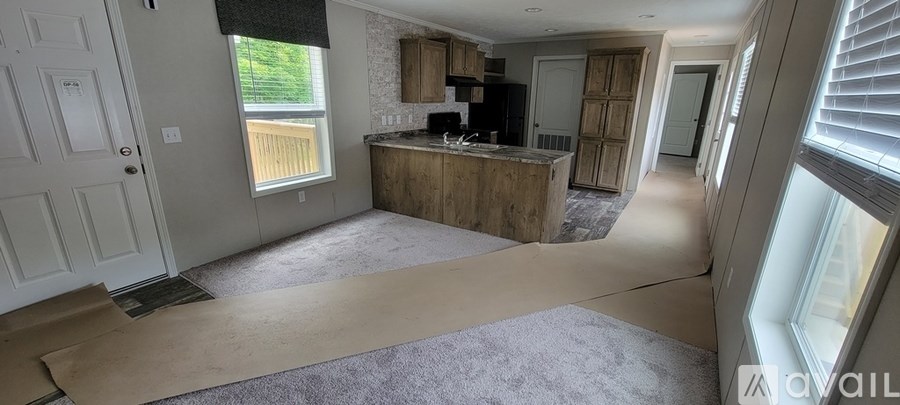 A room with a kitchen area and a large window.