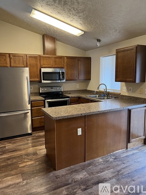 A kitchen with wooden cabinets and a granite countertop.