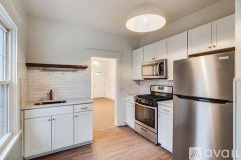 A kitchen with white cabinets and stainless steel appliances.