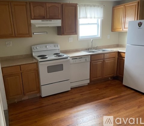 A kitchen with wooden cabinets and white appliances.