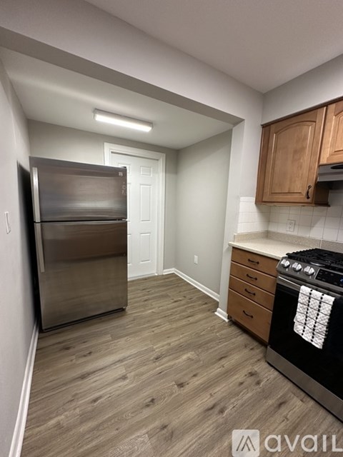 A kitchen with a stainless steel refrigerator and a black stove top oven.